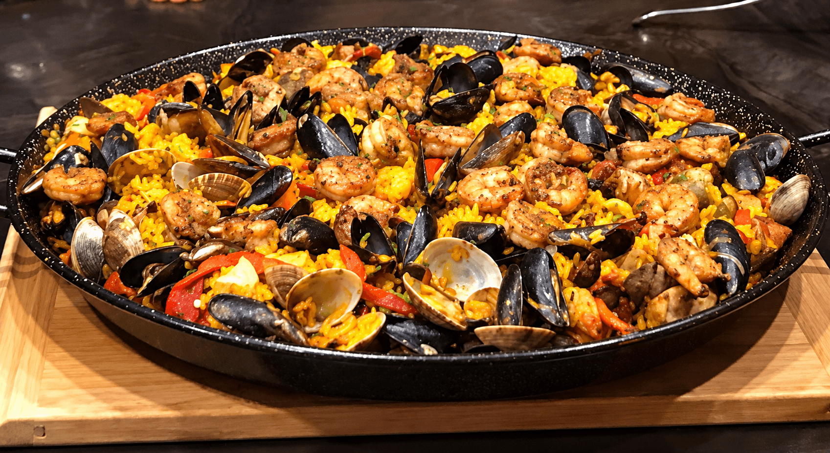 A full pan of Gloria's Paella Mixta, richly presented with seafood and colorful ingredients.