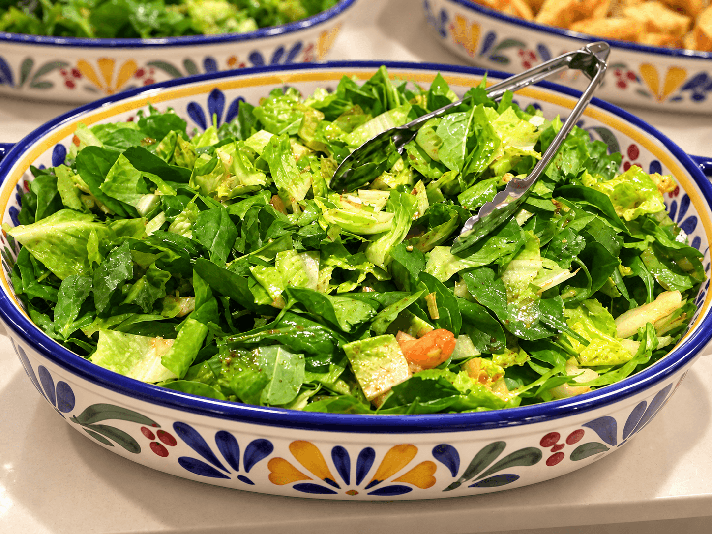 Fresh green salad served in a colorful platter.